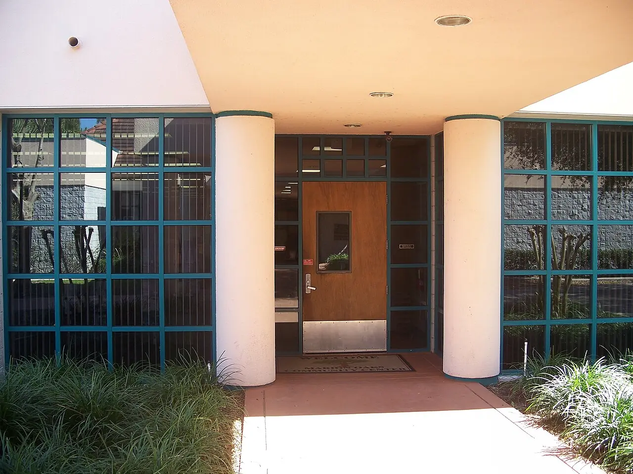 The community library building in Marion Oaks, a low brick building behind a lawn and young trees.