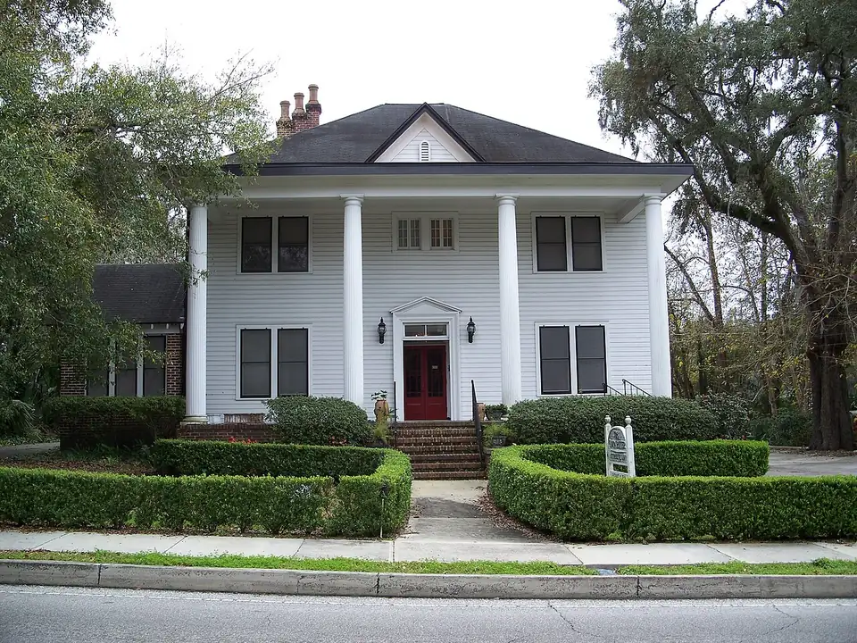 A shaded street in Ocala's historic district, older frame and brick houses set back behind mature oaks.