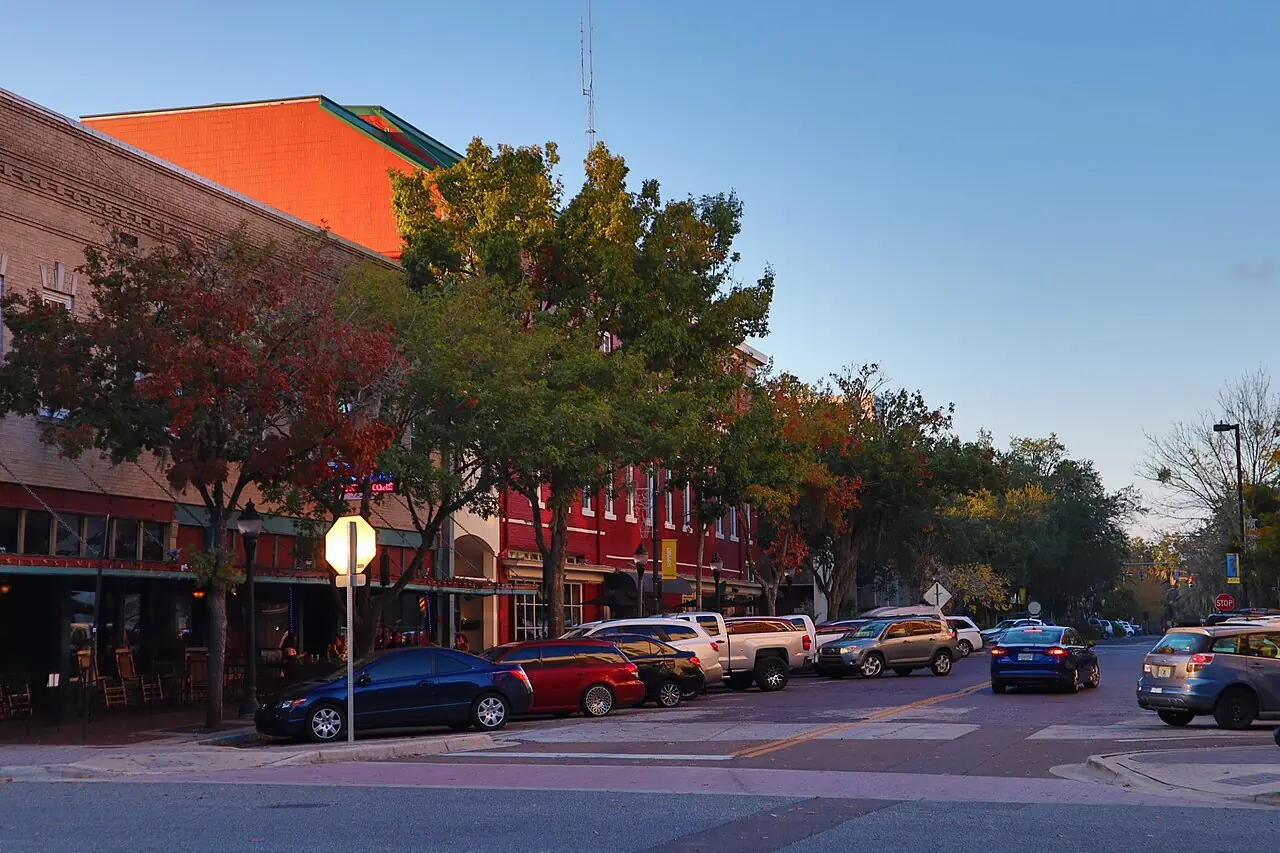 A street in downtown Gainesville, Florida, with low brick buildings and a wide pavement.