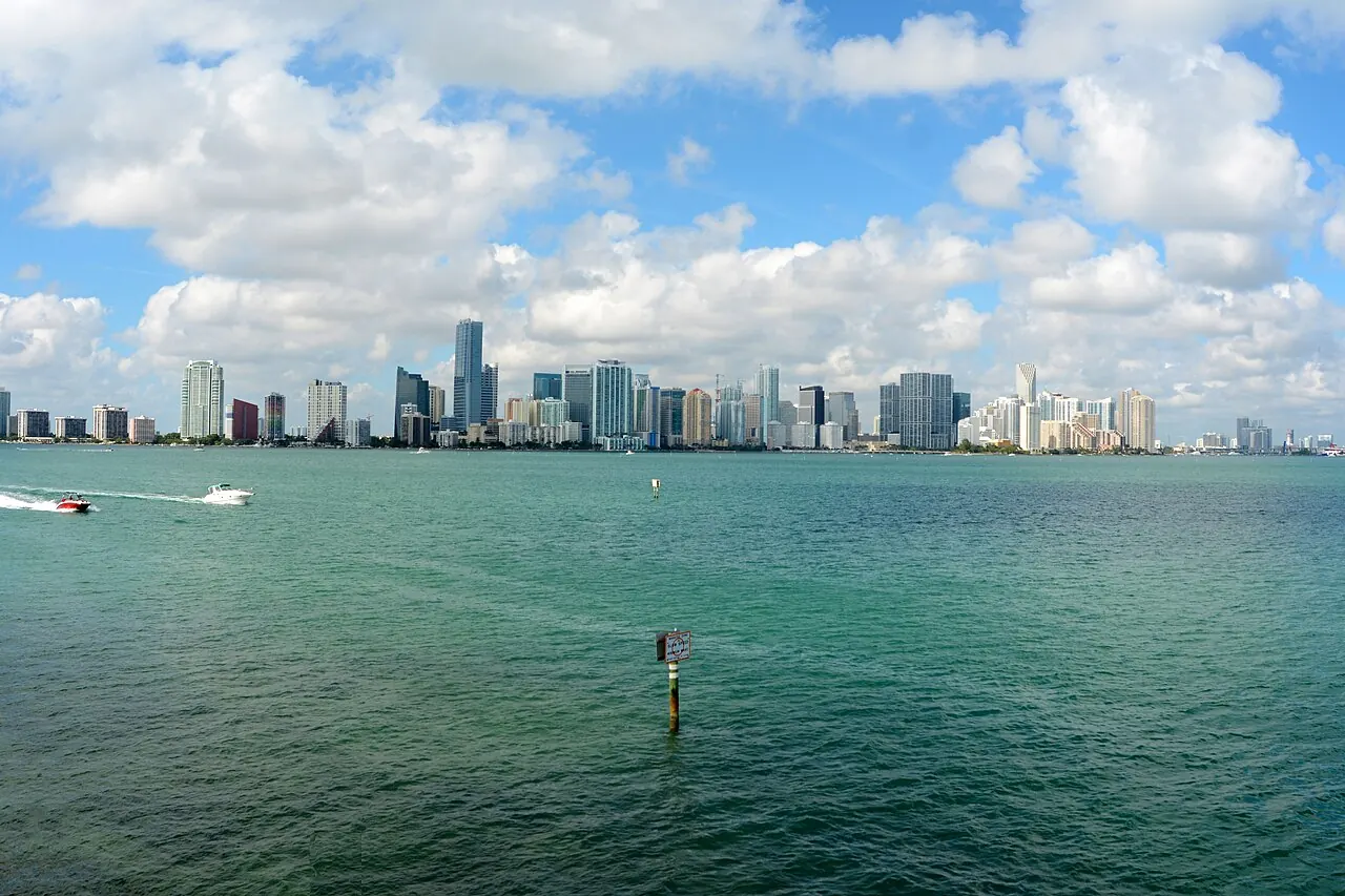The downtown Miami skyline in daylight, seen across Biscayne Bay.
