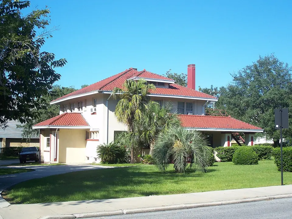 The porch and front steps of a weatherboard house in Ocala's historic district, framed by shrubs.