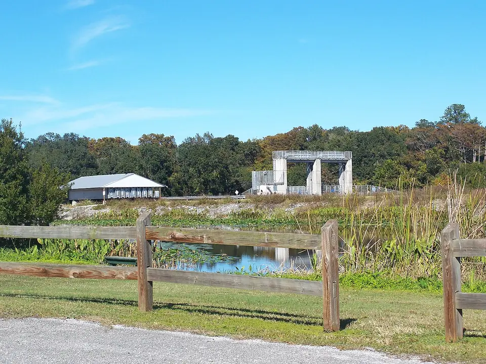 The Moss Bluff Lock and Dam on the Ocklawaha River in Marion County, seen across a split-rail fence and lily pads.