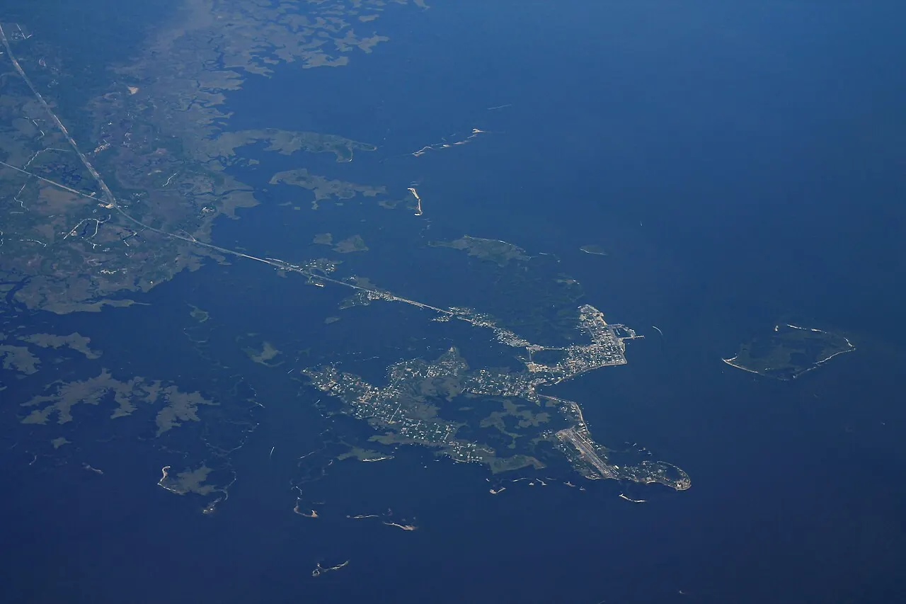 An aerial view of Cedar Key, a low island town in the Gulf with shallow water and salt marsh around it.