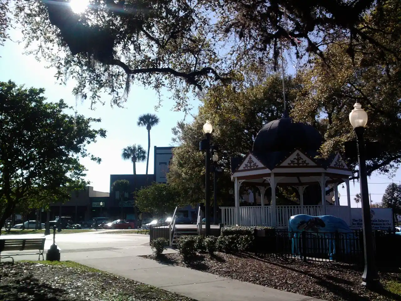 Ocala's downtown square in winter light: a white Victorian gazebo under live oaks hung with Spanish moss.